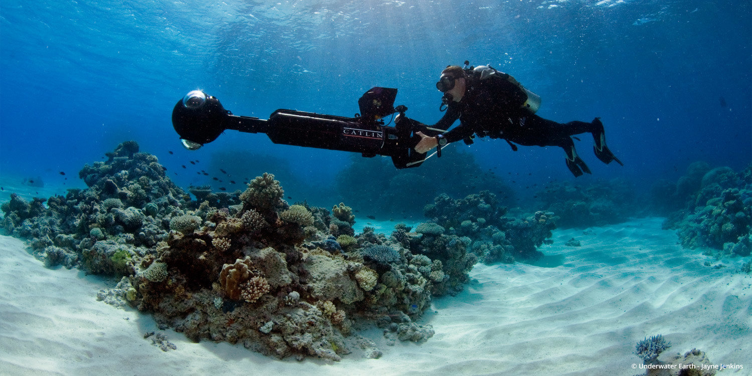 A diver operating the panoramic underwater camera rig above a coral reef